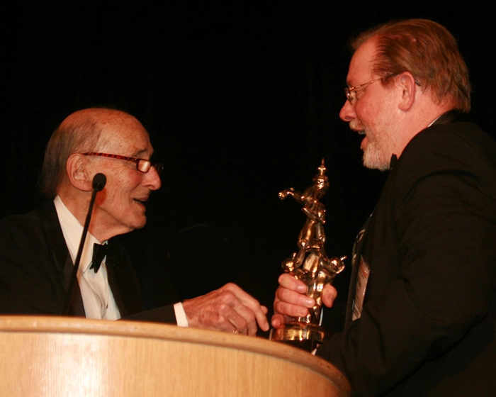 Wiley Miller accepts Reuben Award from Mell Lazarus